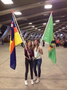 Jongeren uit Hoogland en Hooglanderveen dragen de dorpsvlaggen in de Pius X basiliek in Lourdes